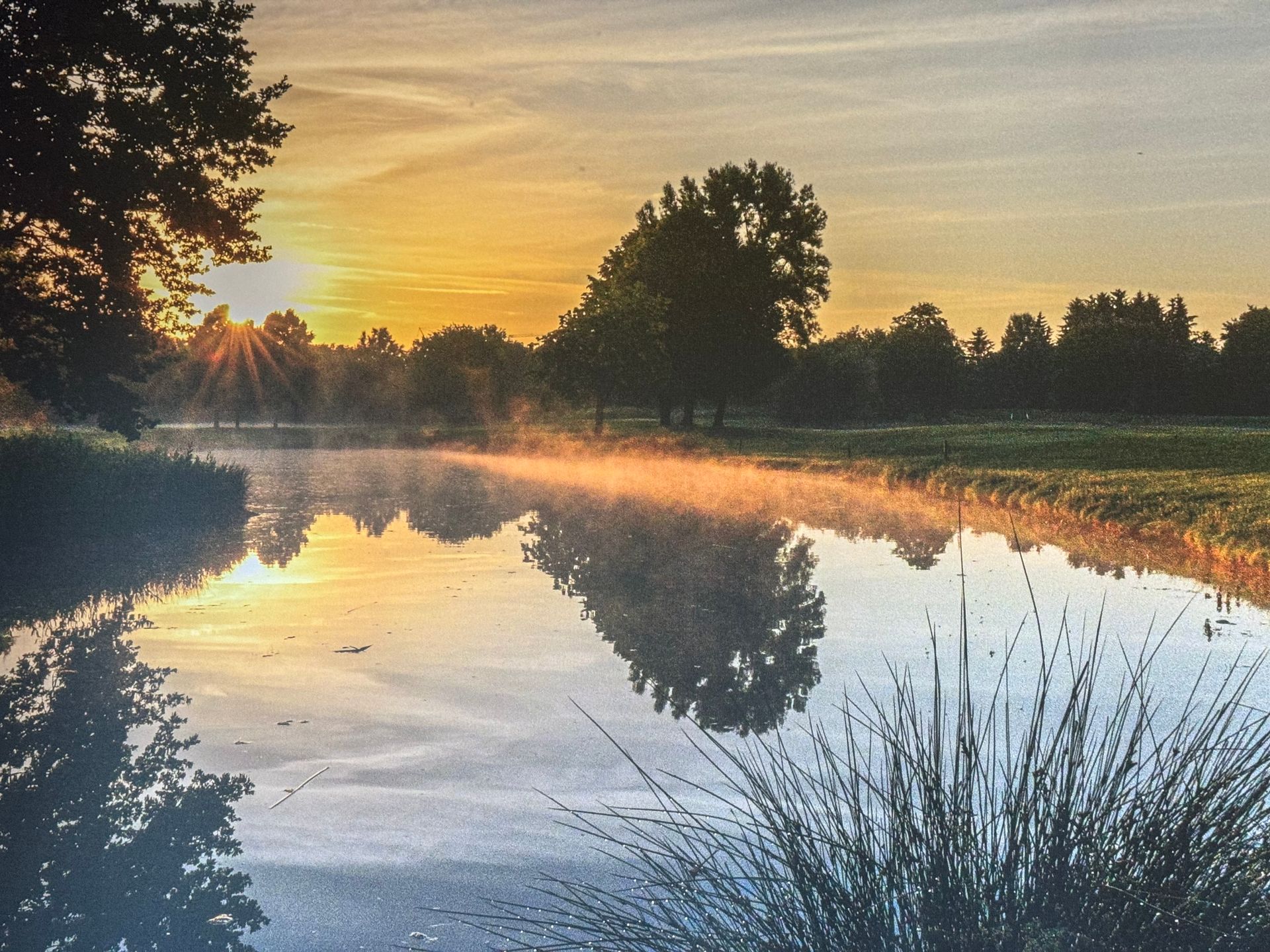 Blick auf den See des Golfplatzes beim Restaurant Olching während des Sonnenuntergangs