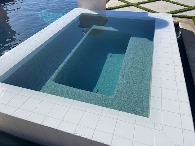 Rectangular pool with white tile edging and steps; pool water is light blue.