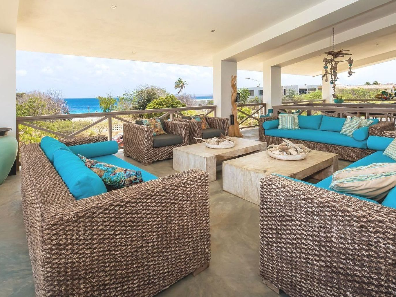 A living room with wicker furniture and a view of the ocean.