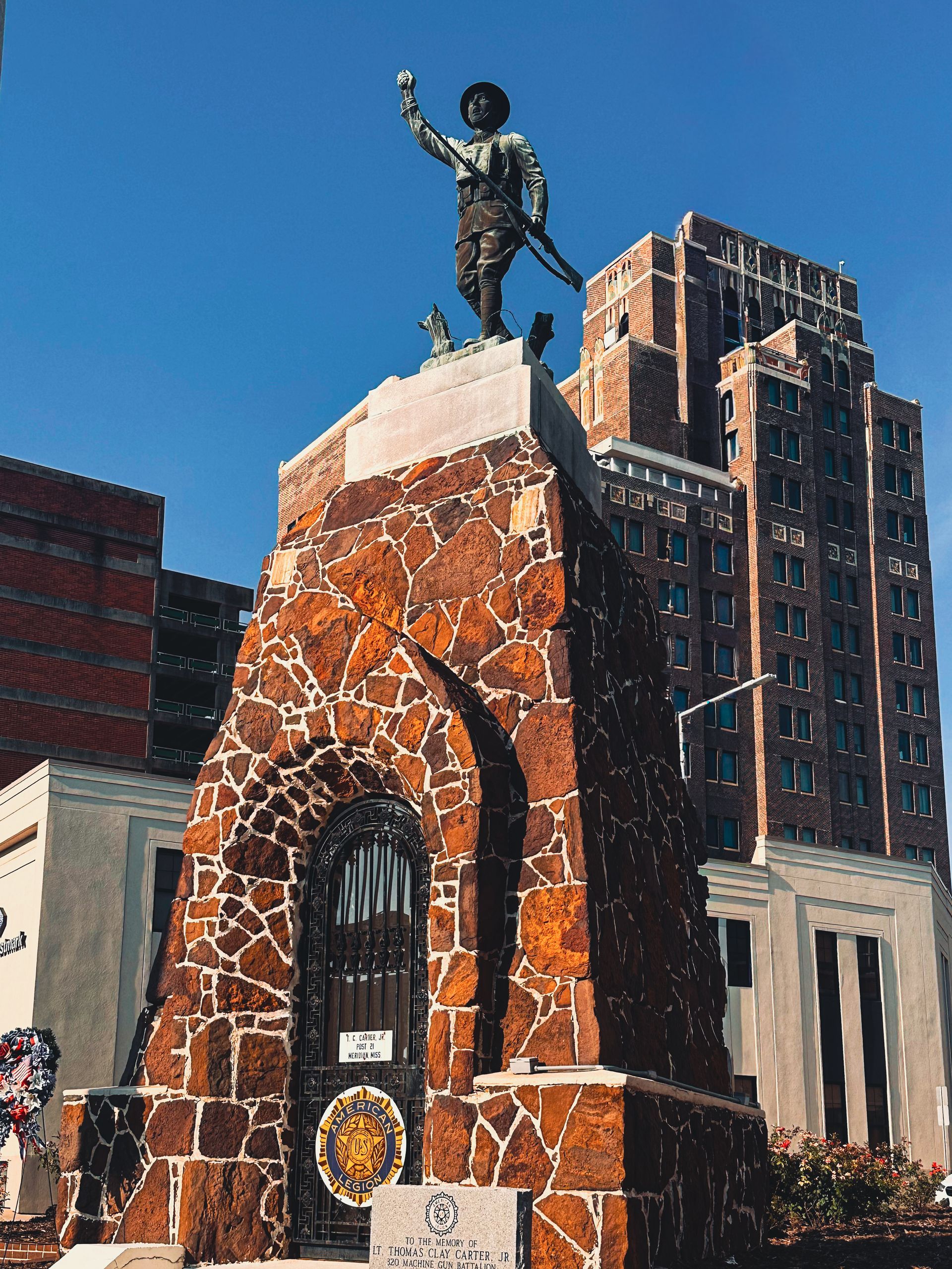 Close-up of a cluster of white roses with soft, creamy centers, surrounded by green leaves.