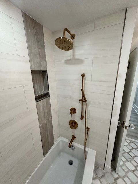 A bathroom with a bathtub and a shower head