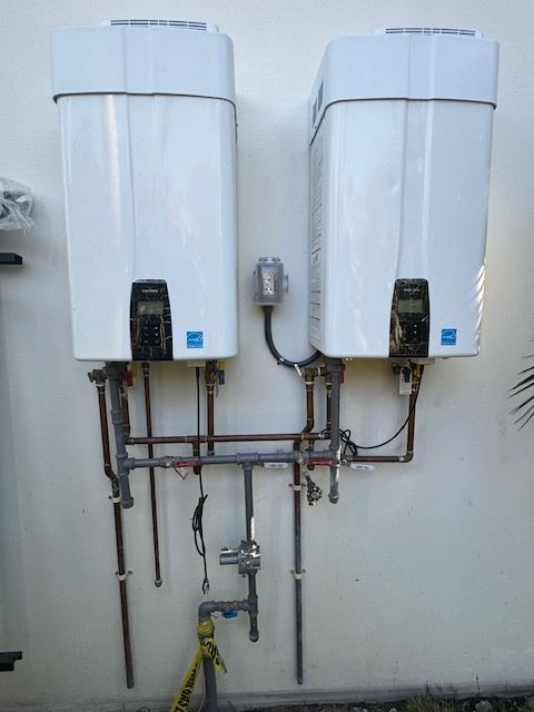 Two white water heaters attached to a white wall