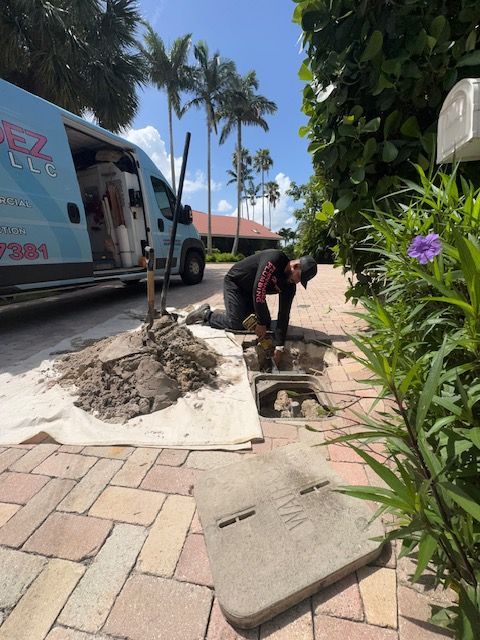 A man is working on a drain in front of a van
