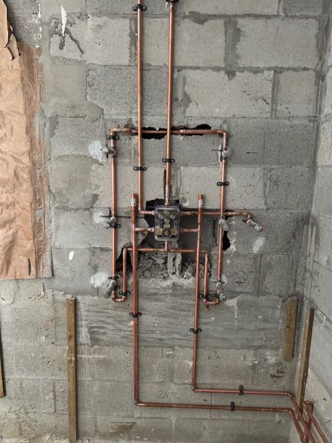 A brick wall with copper pipes coming out of it