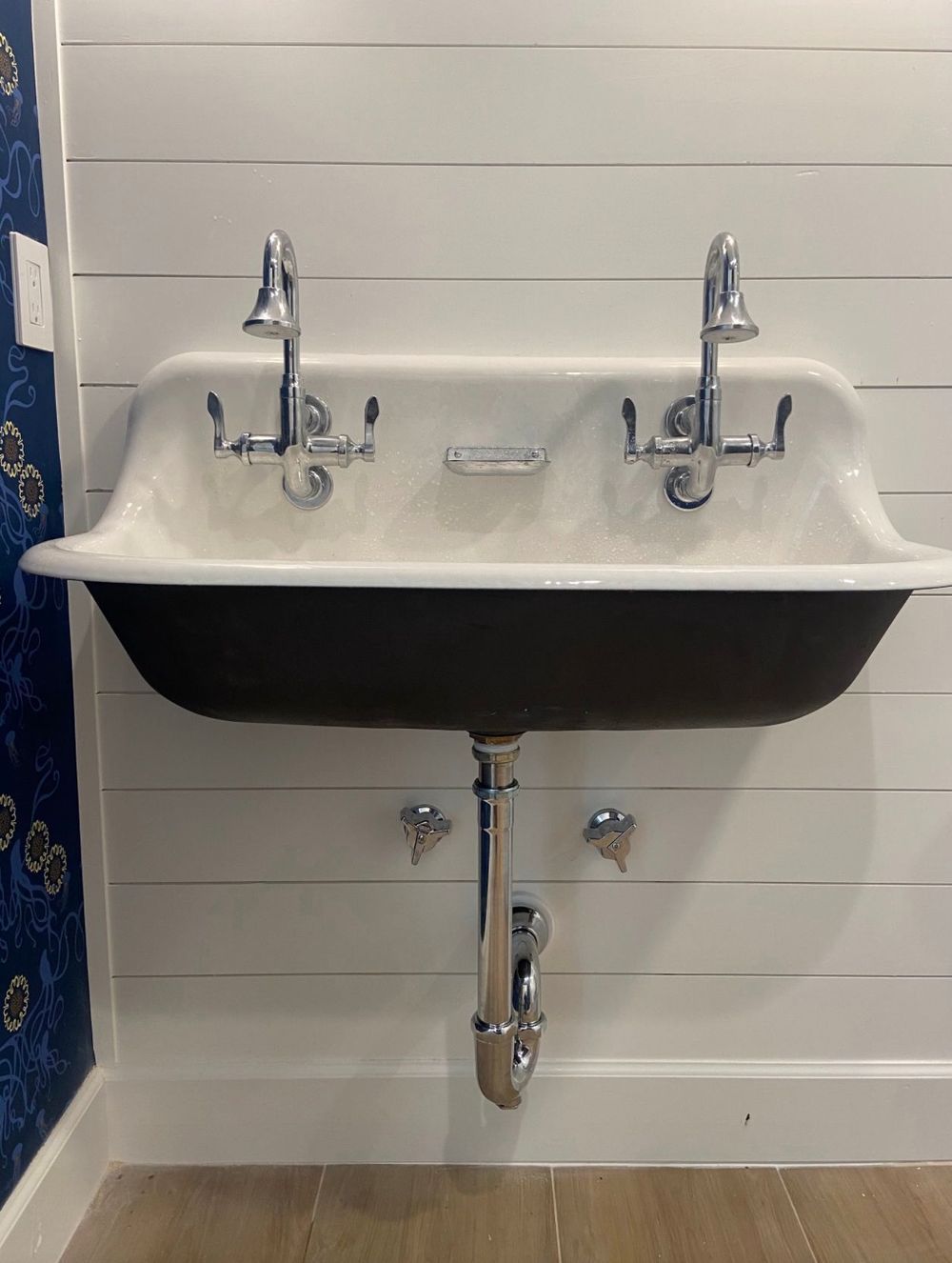 A bathroom sink is hanging on a white wall.