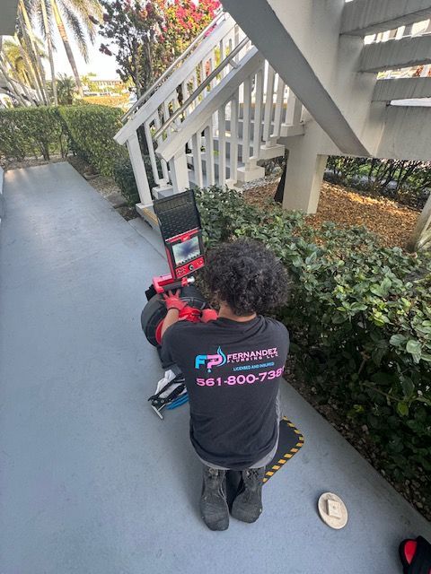 A man is kneeling down on a sidewalk next to a staircase.