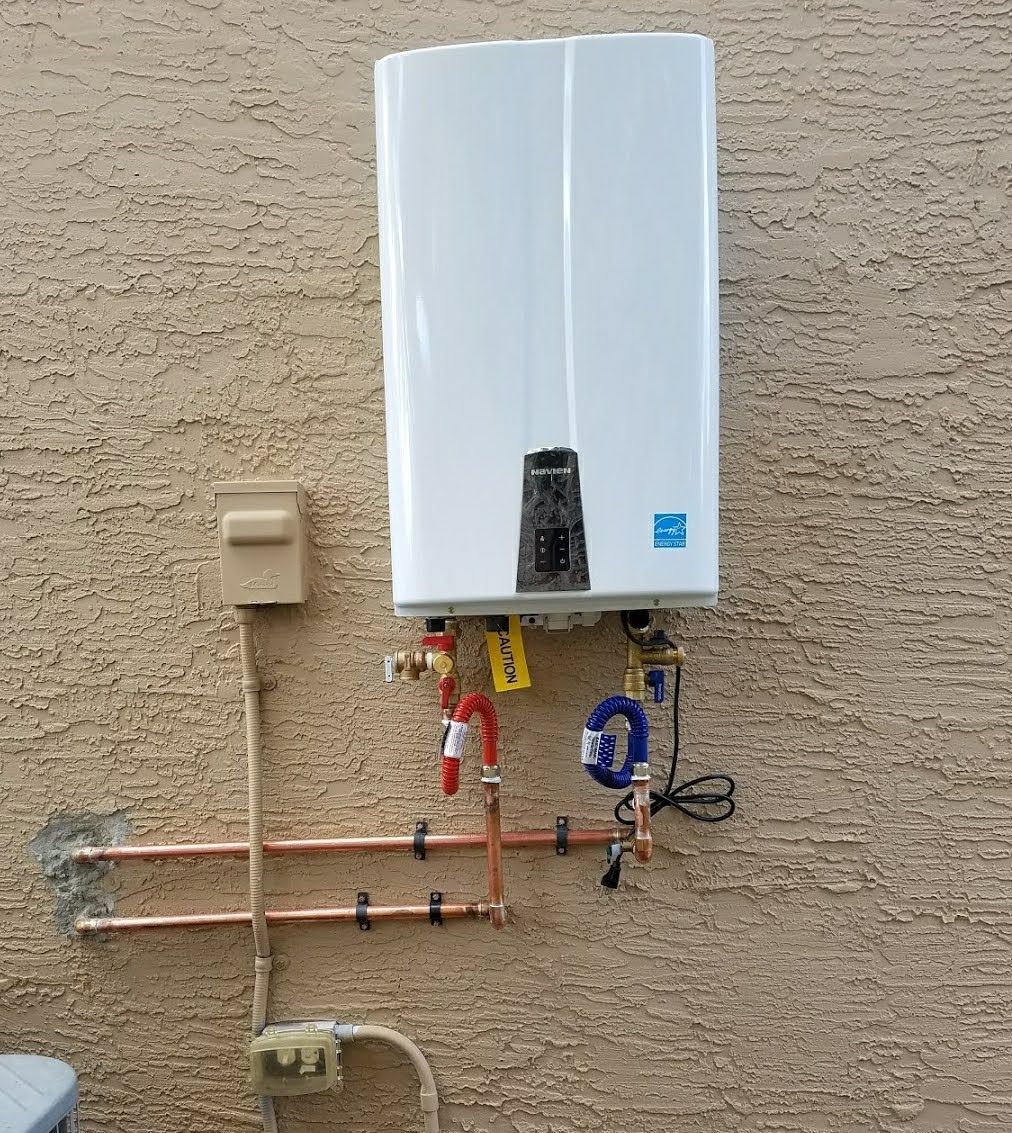 A white water heater is attached to a brick wall.