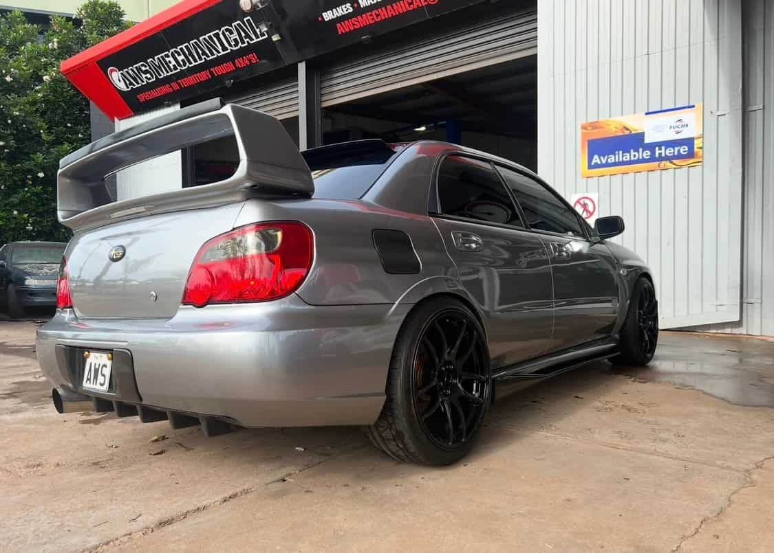 A Silver Car With a Spoiler on the Back is Parked in Front of a Garage  — AWS Mechanical in Stuart Park, NT
