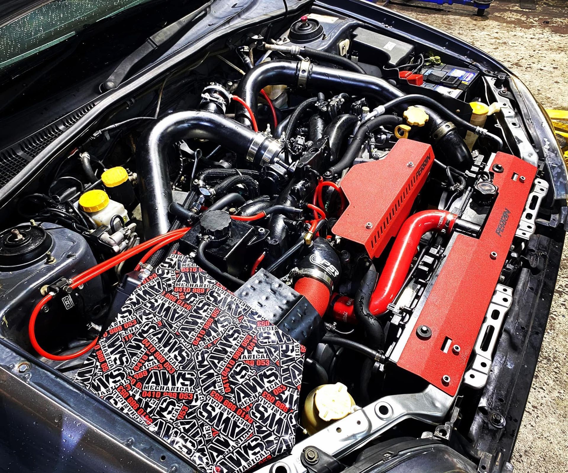 A Car is in a Mechanic's Garage with the Hood of the Car up — AWS Mechanical in Stuart Park, NT