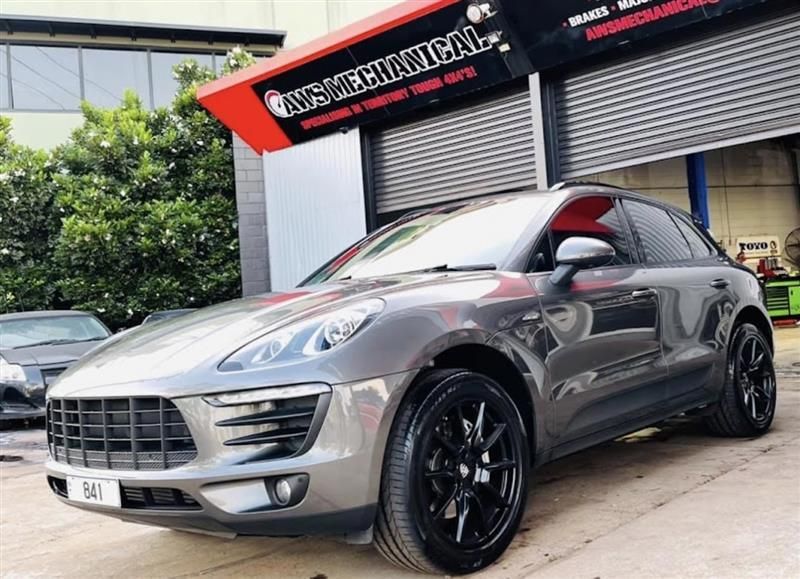 A gray porsche macan is parked in front of a garage. — AWS Mechanical in Stuart Park, NT