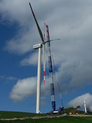 Una grande turbina eolica è in costruzione in un campo