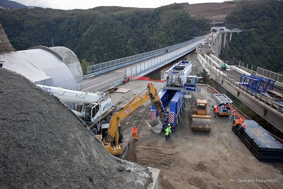 Un cantiere con un ponte sullo sfondo.