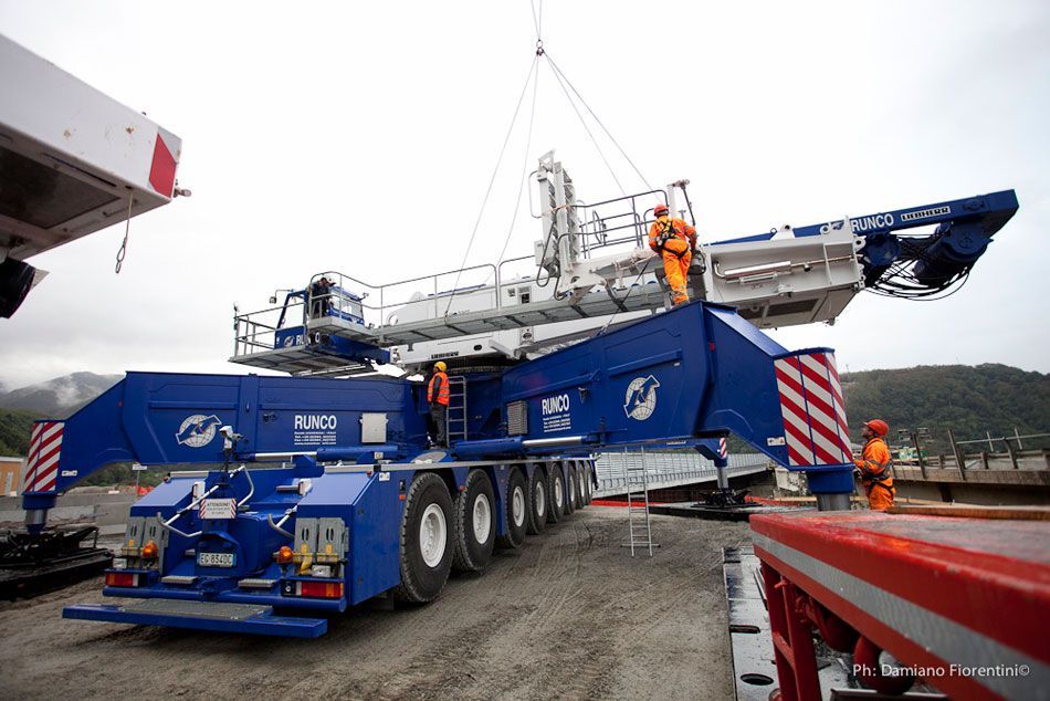 Una grande gru blu e bianca viene sollevata da una gru.