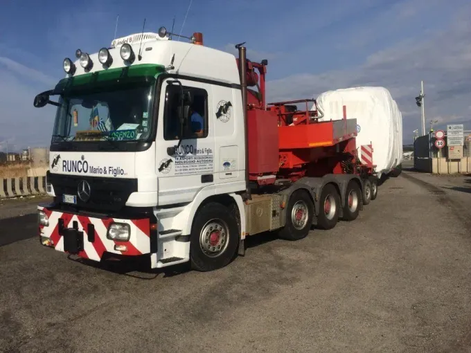 Un camion bianco e rosso con la scritta Paco sul davanti è parcheggiato sul ciglio della strada.