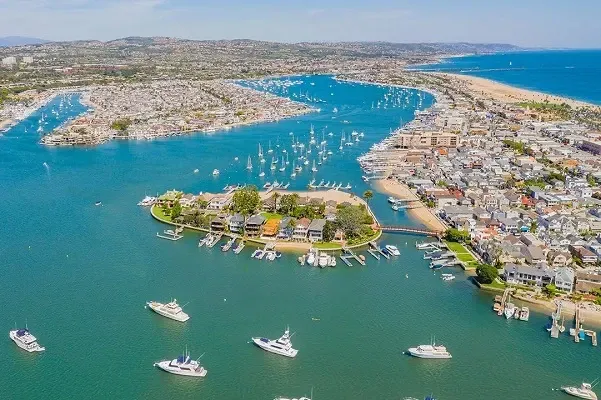 An aerial view of a harbor with boats and a small island in the middle.