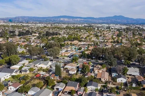 An aerial view of a residential area with mountains in the background.