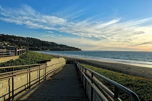 There is a walkway leading to the beach and the ocean.