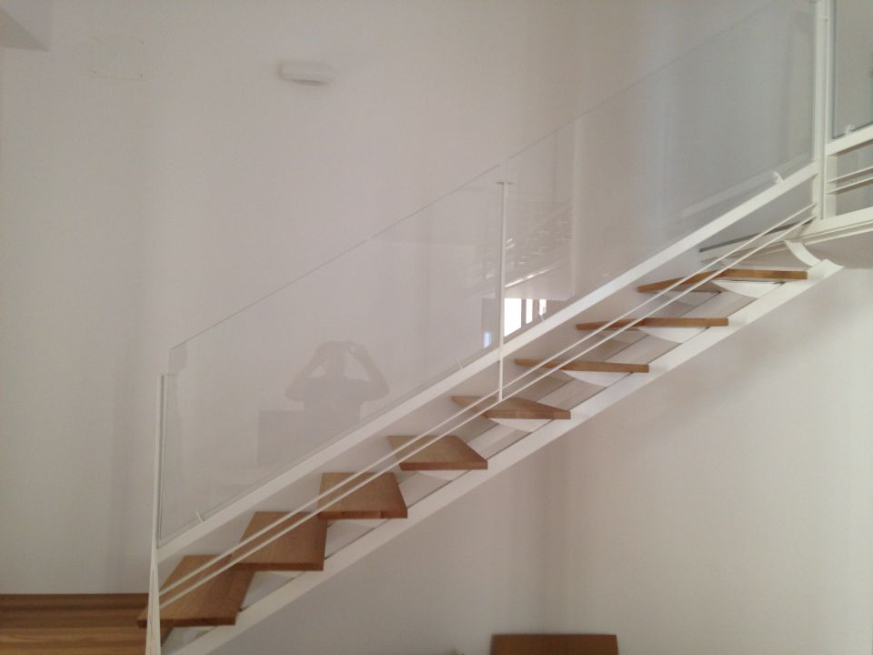 scala con gradini in legno e ringhiera in cristallo