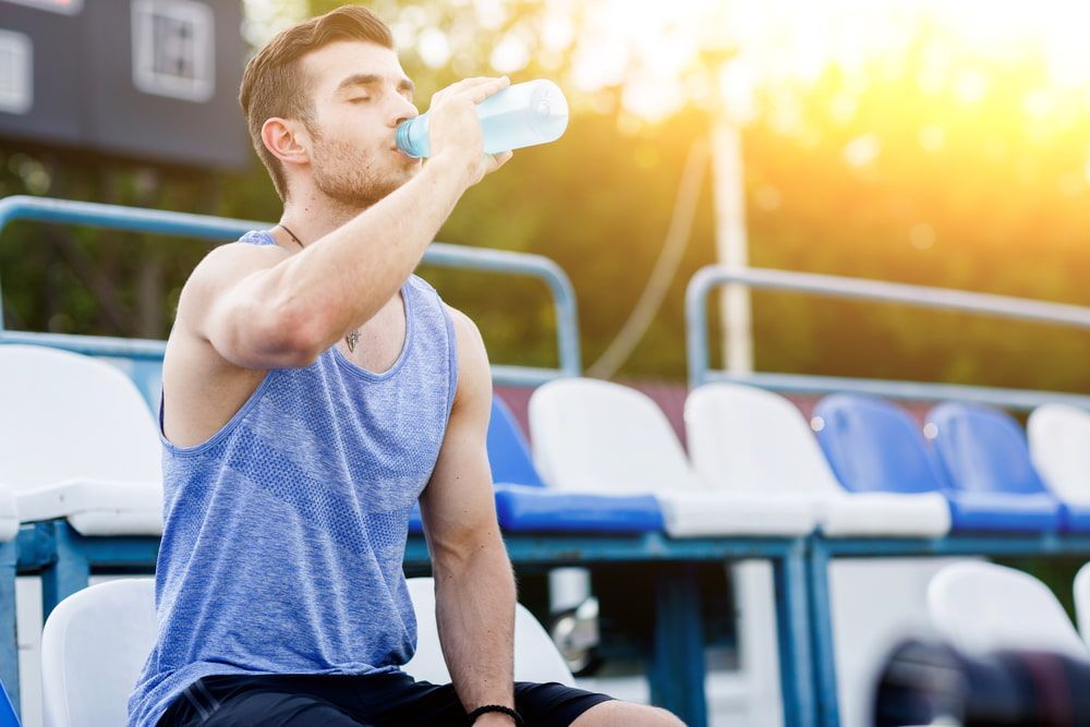 Man in Blue Tank Top Drinking Water in Stadium — Port Macquarie Pure Water In Kempsey, NSW