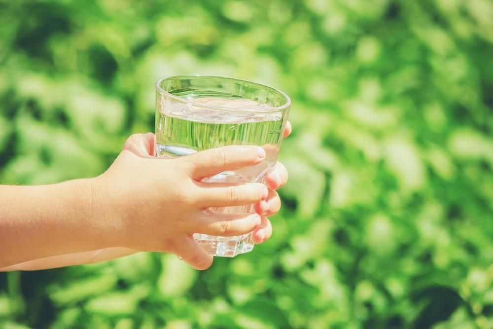 Child's Hands Holding a Glass of Water — Port Macquarie Pure Water In Taree, NSW