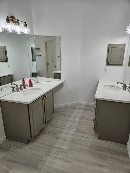 A bathroom with two sinks and a large mirror.