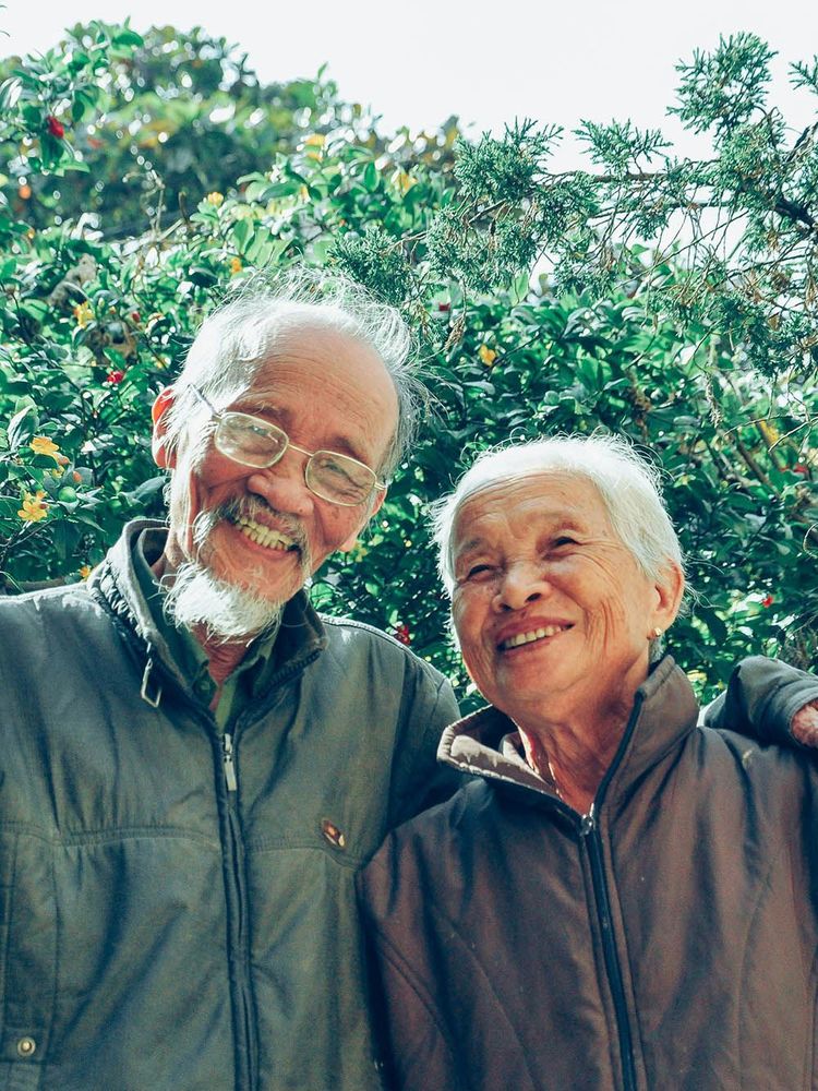 A man and a woman are posing for a picture together and smiling.