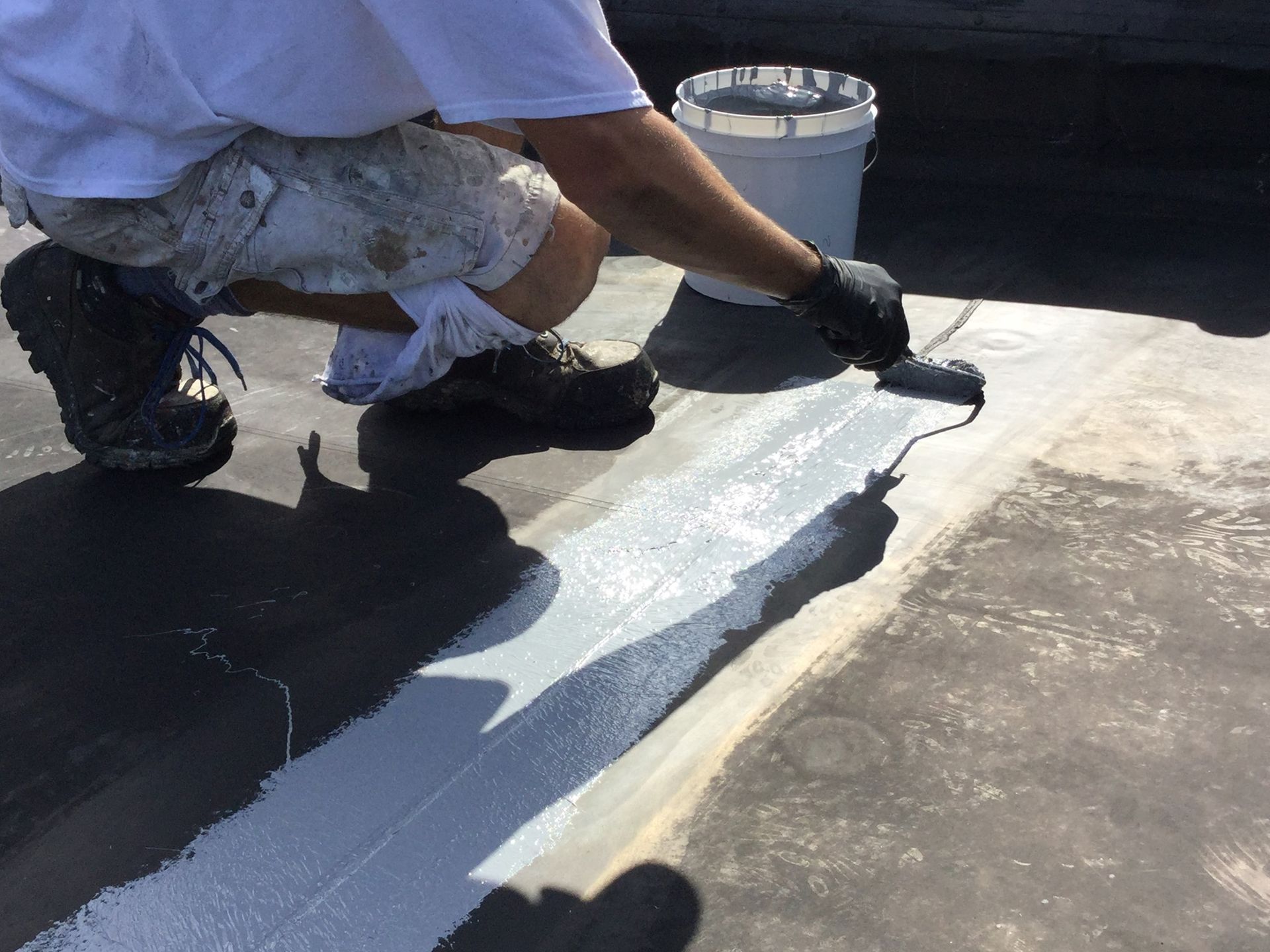 applying sealant to cracks on a roof