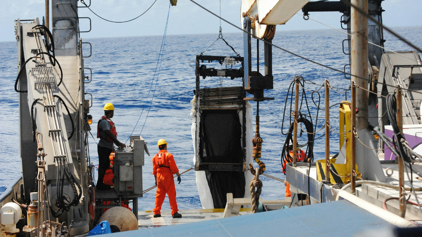 A group of men are working on a boat in the ocean