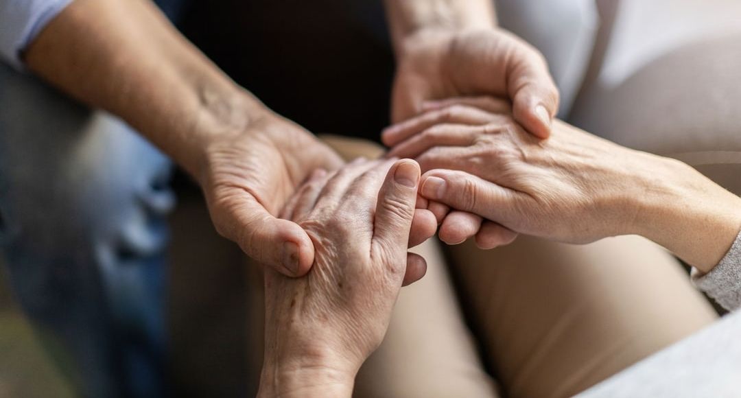 younger person holding the hands of an older person
