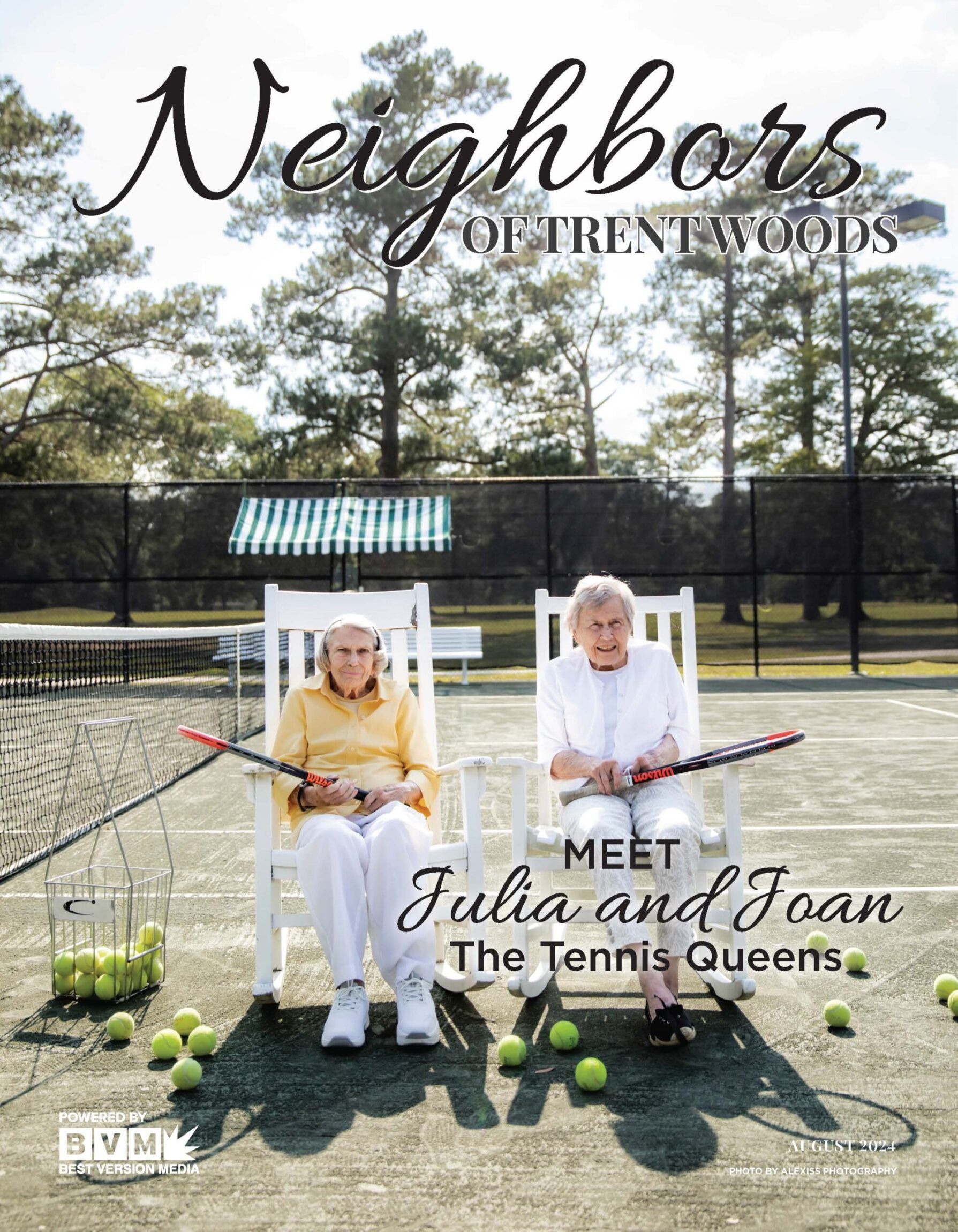 Two people sit in white rocking chairs on a tennis court, holding rackets with tennis balls scattered around them.