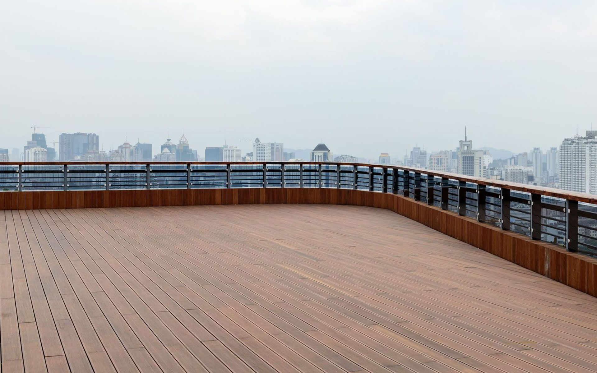 An empty wooden deck with a city skyline in the background.