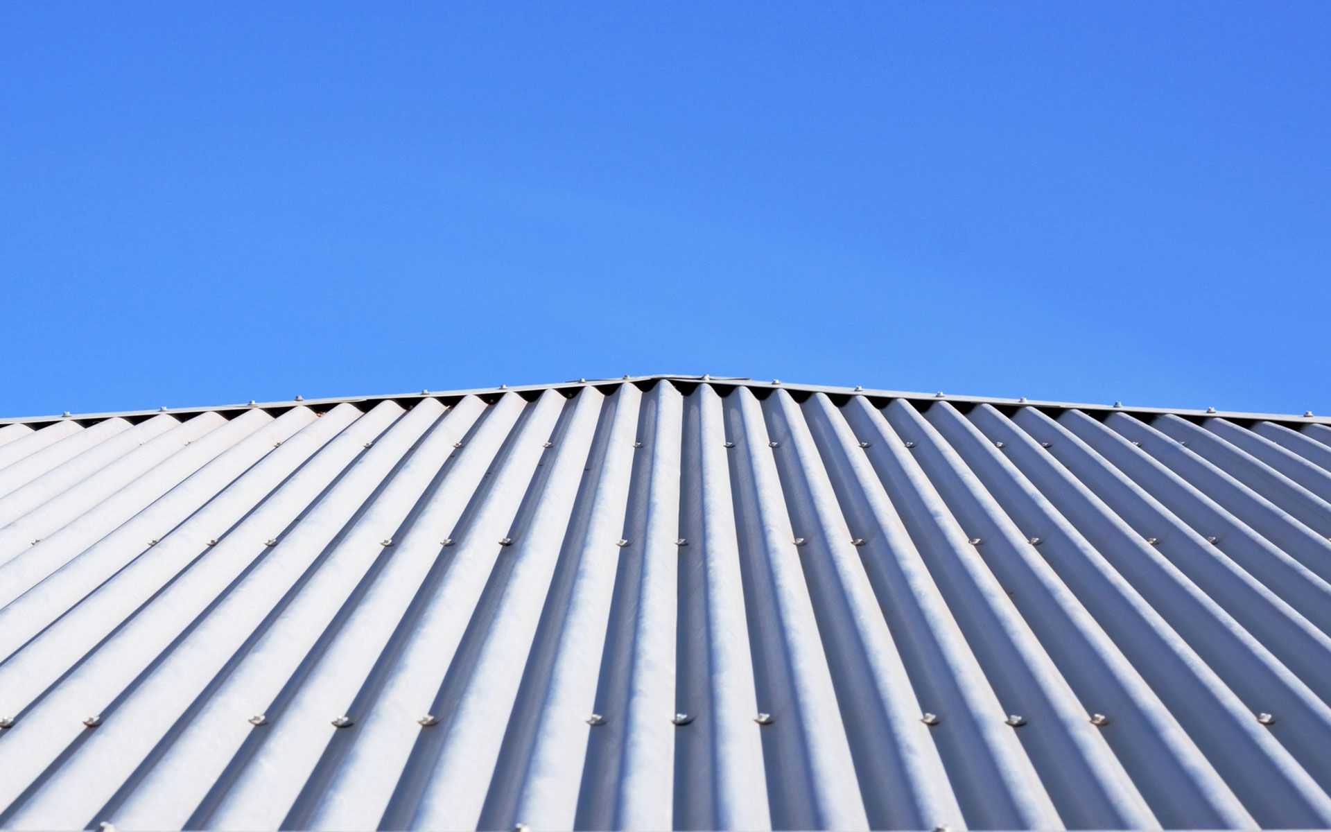 Looking up at the roof of a building with a blue sky in the background