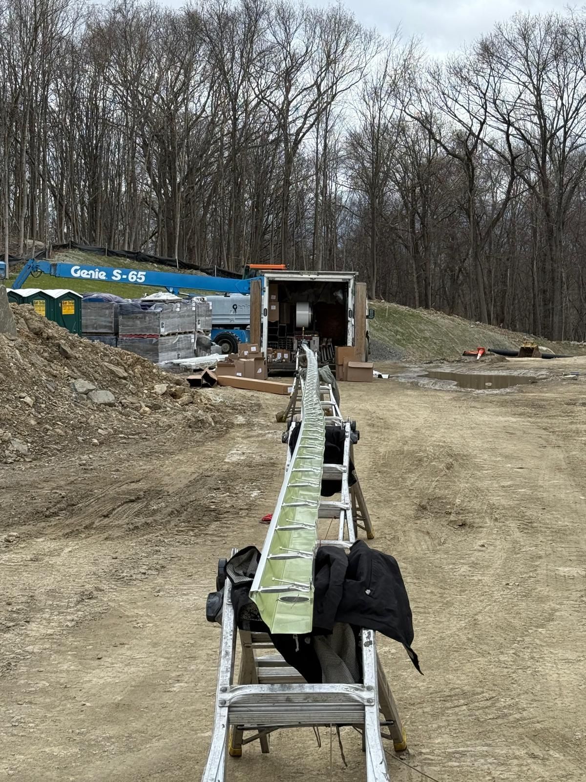 A man is installing a gutter on the roof of a house.