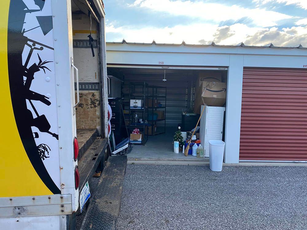 A truck is parked in a garage with the door open.