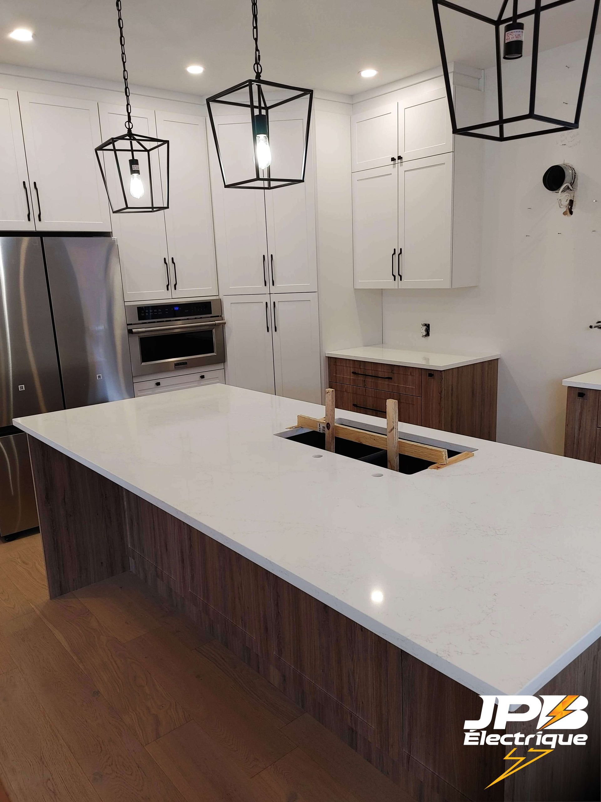 une cuisine avec un comptoir en quartz blanc et des armoires en bois