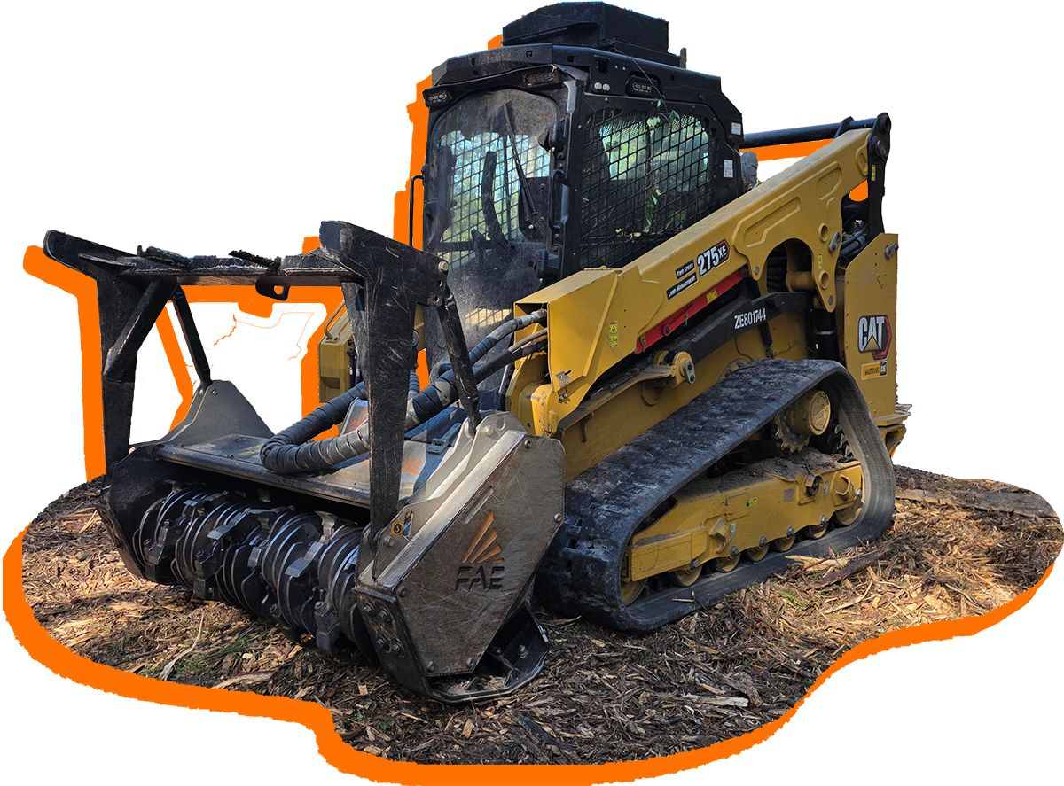 Yellow tracked skid steer with forestry mulcher attachment, working in a wooded area.