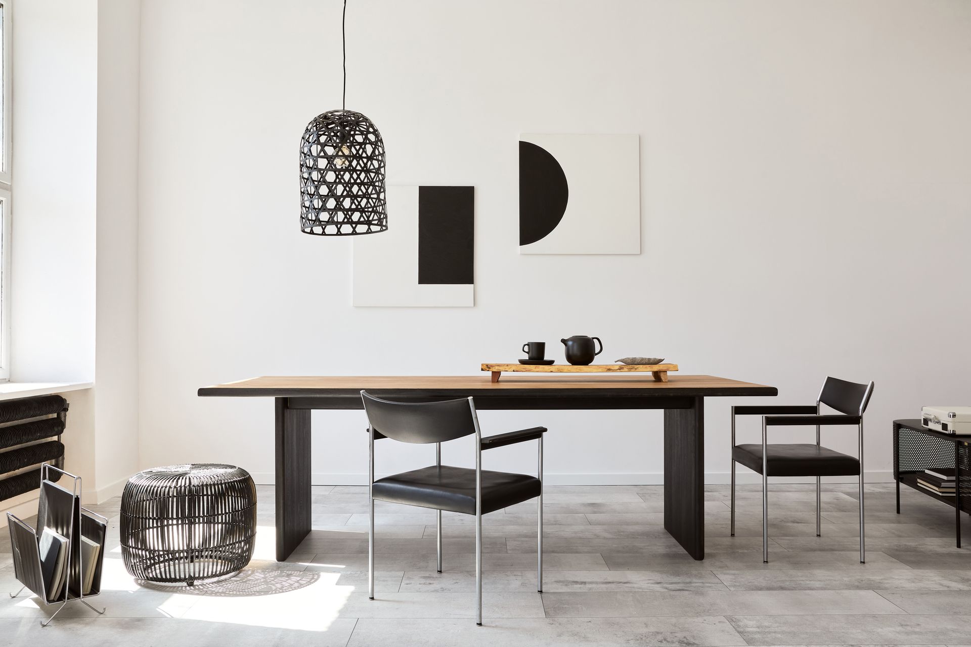 a modern dining room with a sleek, stylish, reclaimed wood table and chairs and a painting on the wall