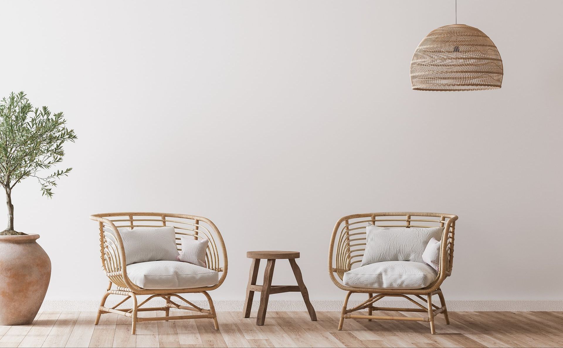 two Scandinavian style wicker chairs and a stool in front of a white wall