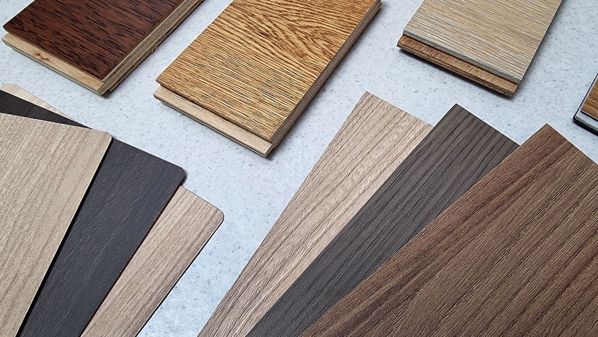 A bunch of different types of wood are laying on a table Real Wood Vs Veneer Vs Laminate