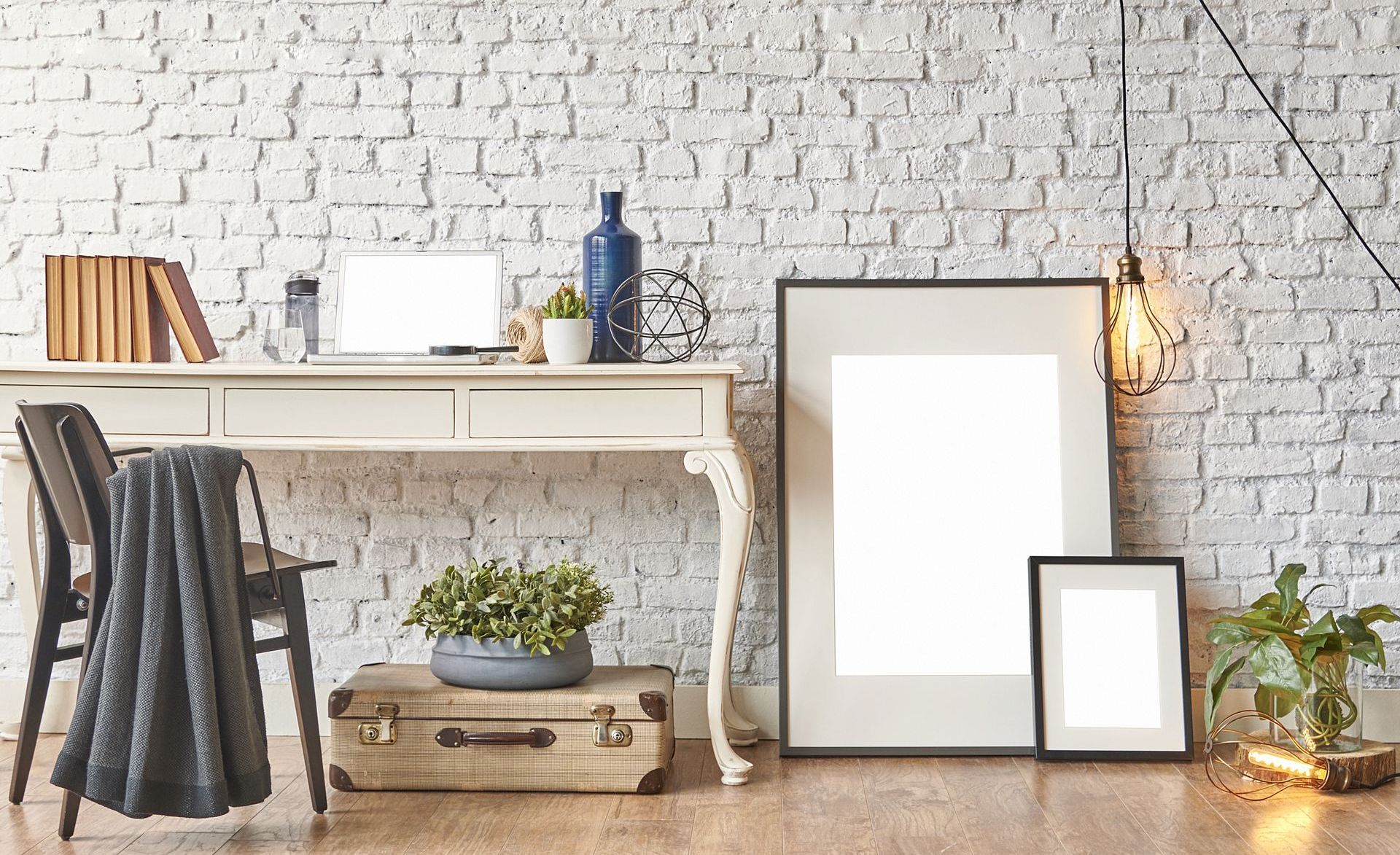 a white brick wall behind a vintage desk with a laptop on it with vintage inspired decor pieces