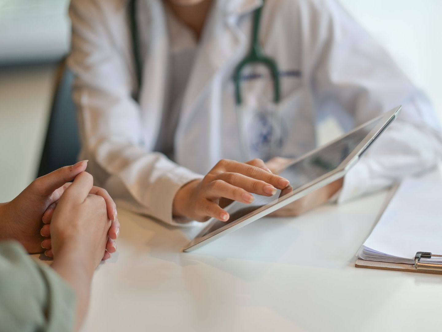 A doctor showing a patient information on a tablet