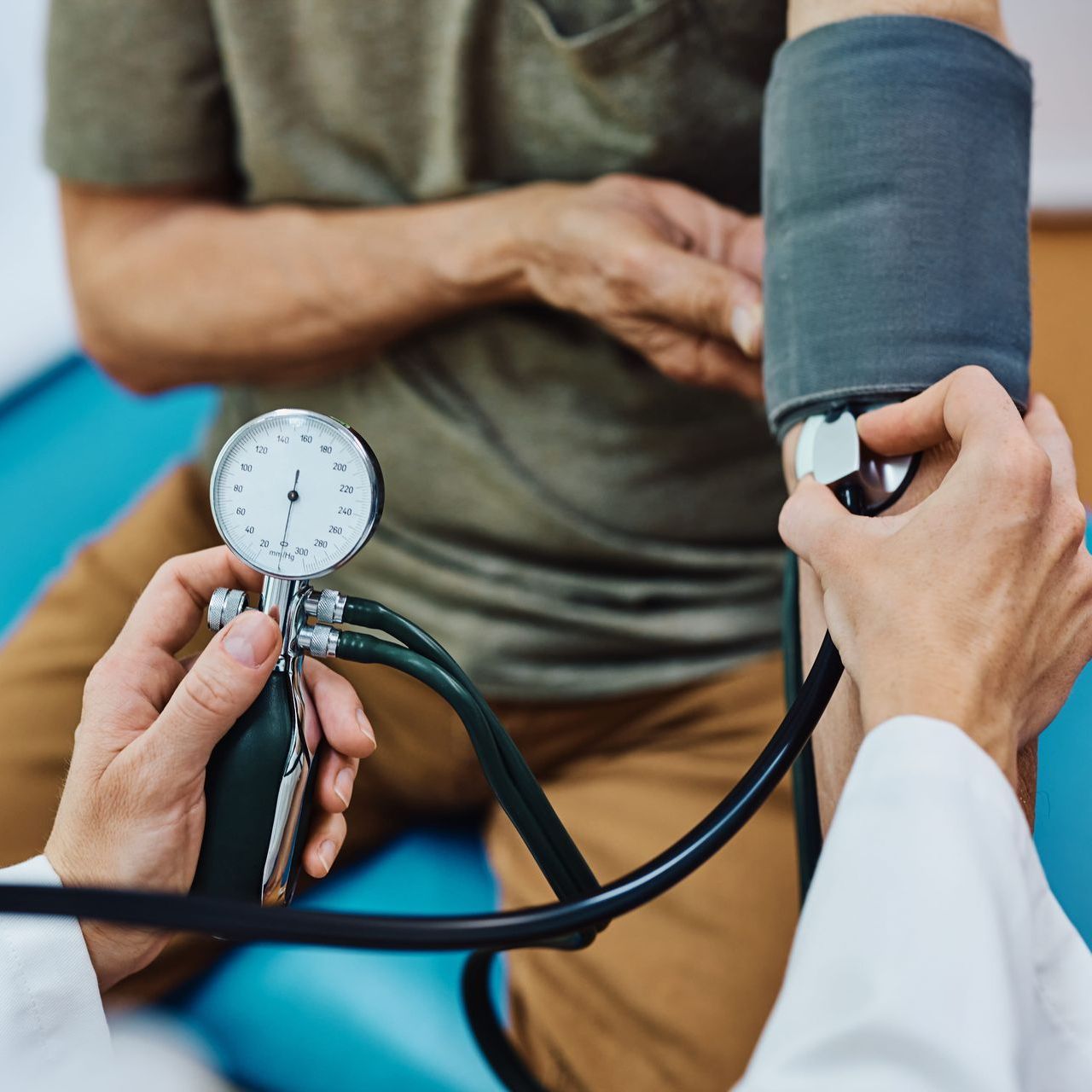 A doctor taking the blood pressure of an older patient