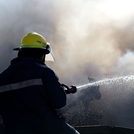 A fireman wearing a yellow helmet with the word fire on it