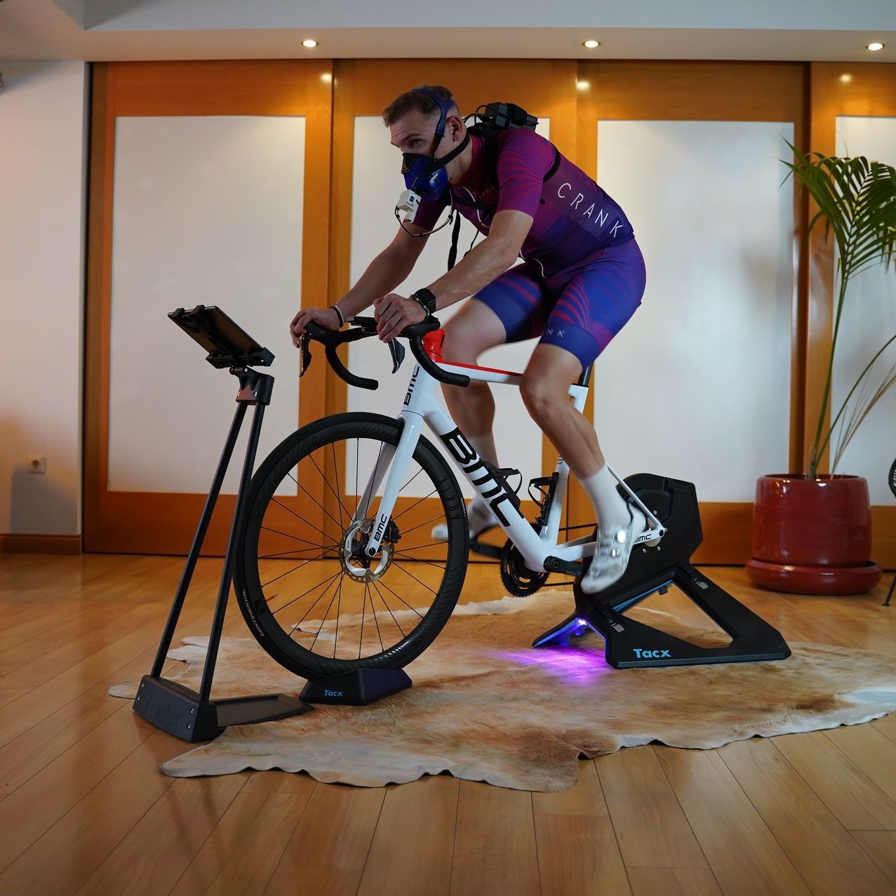 A man wearing a mask is riding a bike that says bmc on it