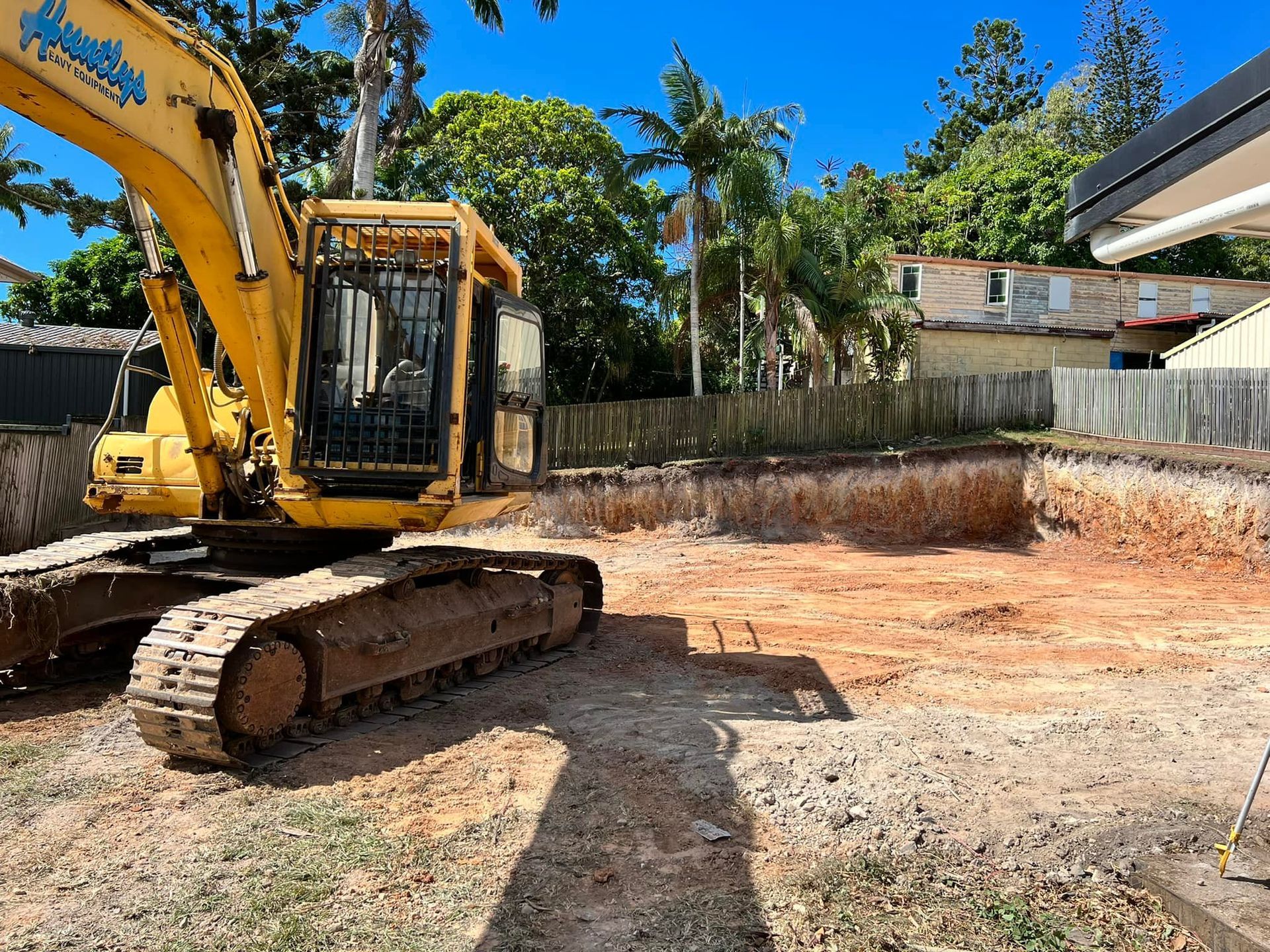 Excavator On The Field Near Houses