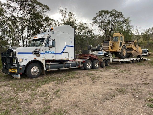 Heavy Machinery Loaded with Yellow Truck — Huntlys Heavy Equipment in Gracemere, QLD