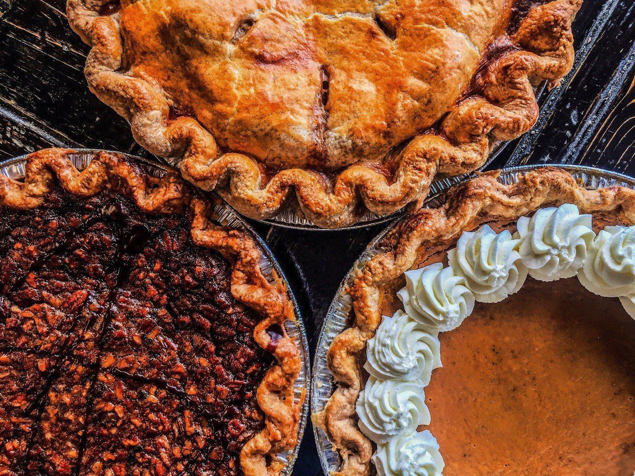 Three different types of pies are sitting on a table.