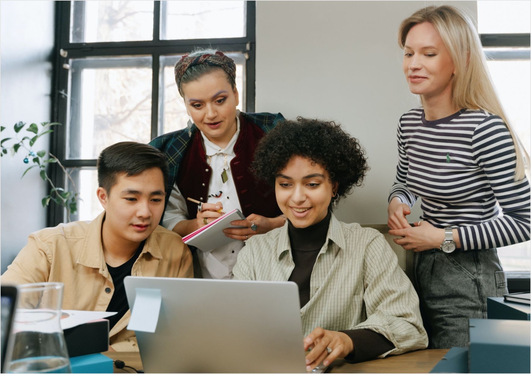 A group of people are looking at a laptop computer.