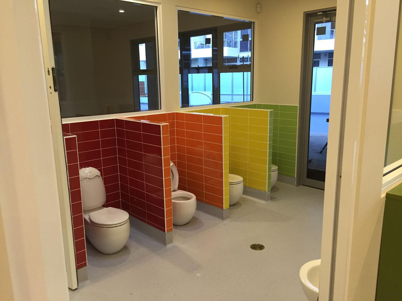 A bathroom with a row of toilets and a sink