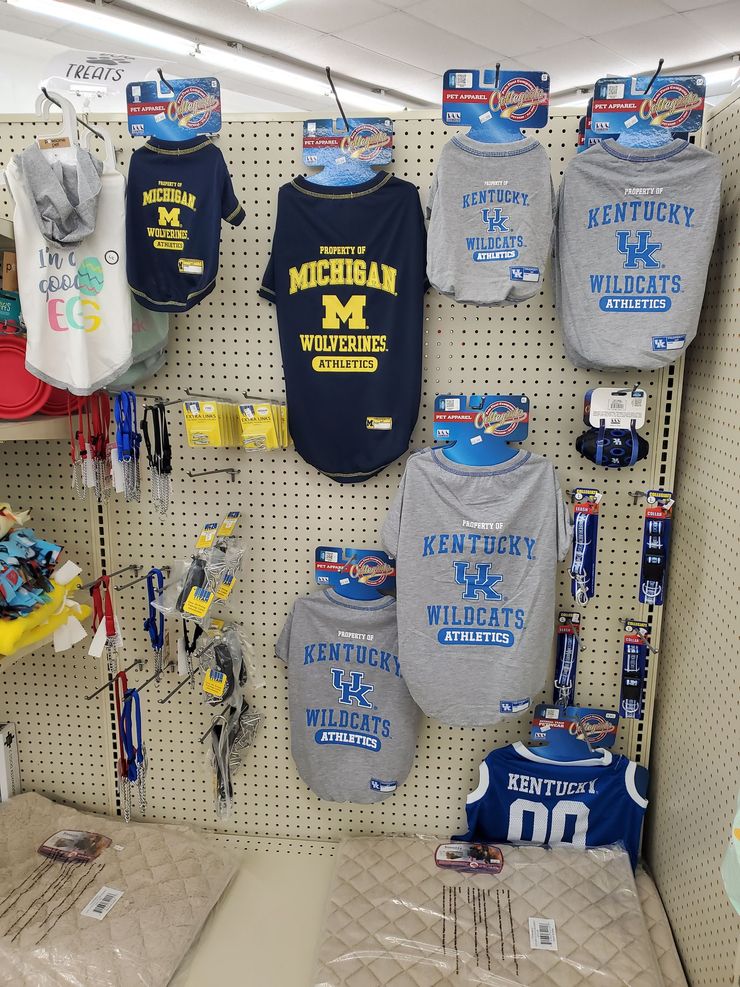 a display of kentucky wildcats and michigan wolverines dog shirts